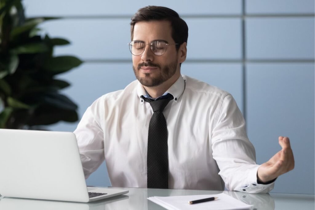 Dirigeant en pleine séance de recentrage mental au bureau, pratique de respiration et pleine conscience face à la surcharge de travail