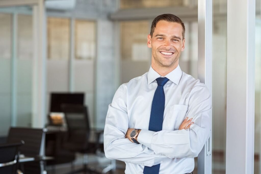 Coach professionnel manager dans un bureau, posturé confiant avec un sourire
