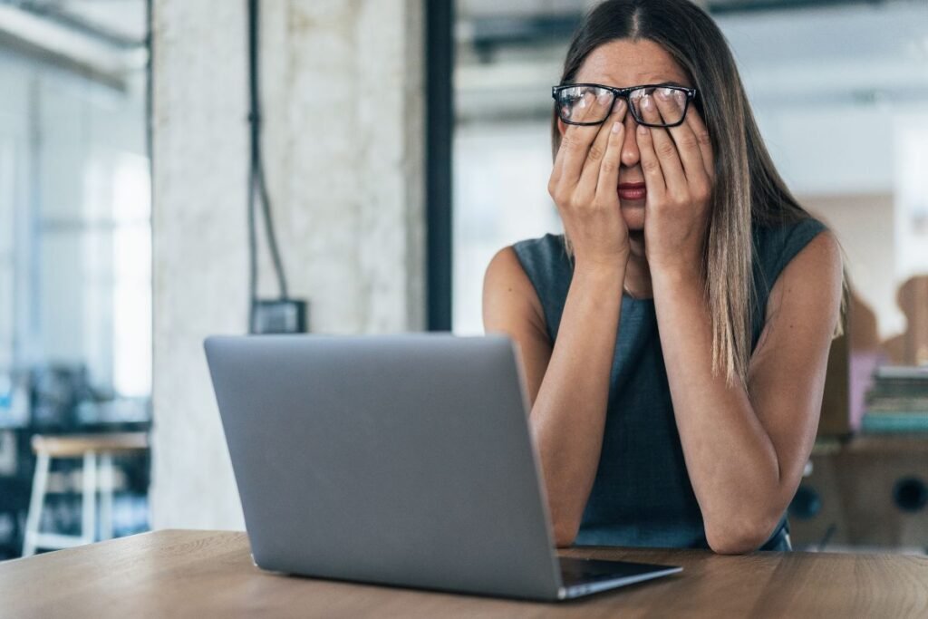 Cadre épuisée devant son ordinateur, submergée par les écrans et les notifications numériques