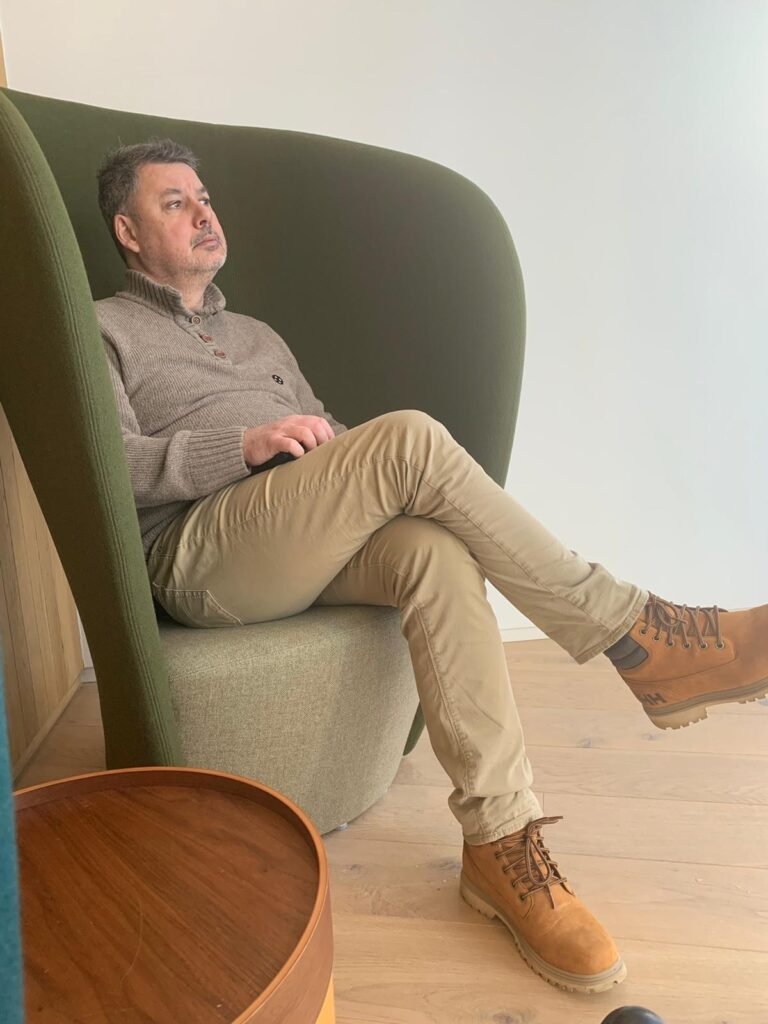 Laurent de Vaucouleurs en réflexion, assis dans un fauteuil design, symbole de prise de recul et de clarté mentale