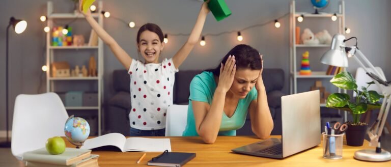 Mère épuisée devant son ordinateur, submergée par la charge mentale du travail, tandis que son enfant joue bruyamment à côté.