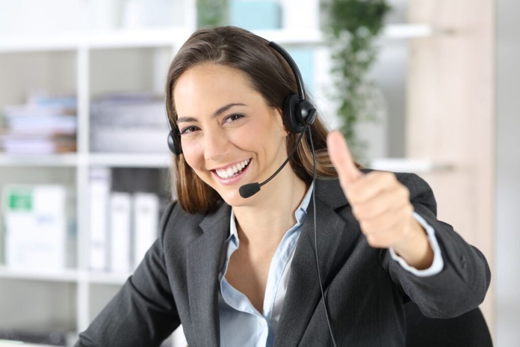 Femme souriante avec casque micro levant le pouce, symbole de confiance retrouvée grâce au coaching professionnel.