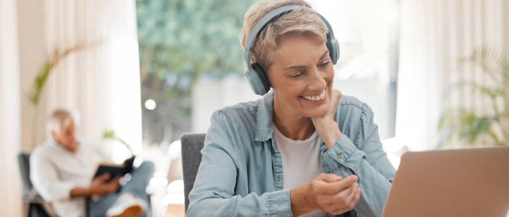 Responsable marketing souriante, reconnectée à son travail après un accompagnement de coaching, chez elle devant son ordinateur