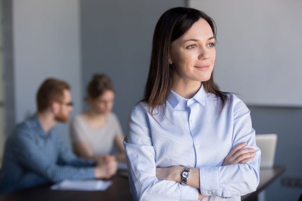 Femme confiante souriante après avoir surmonté une stagnation professionnelle.