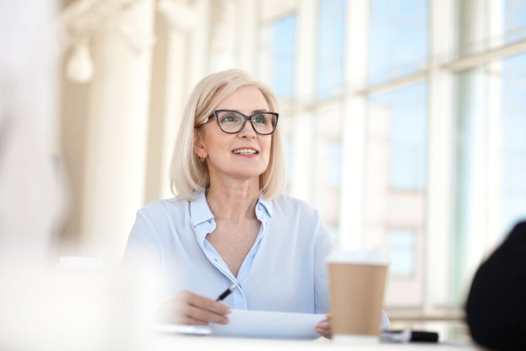 Femme cadre souriante en réunion, en quête de sens dans son travail