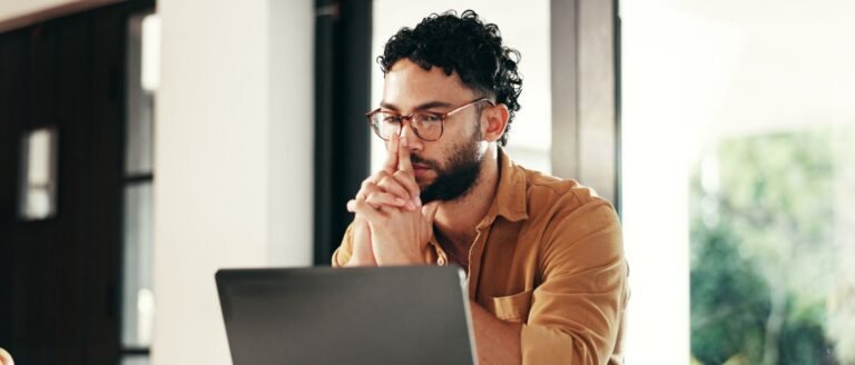 Homme expatrié travaillant seul sur ordinateur, exprimant un isolement émotionnel et professionnel