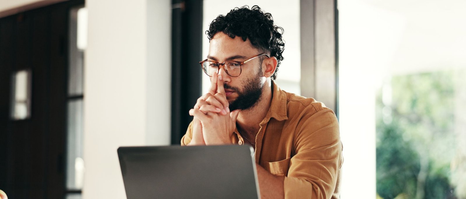 Homme expatrié travaillant seul sur ordinateur, exprimant un isolement émotionnel et professionnel