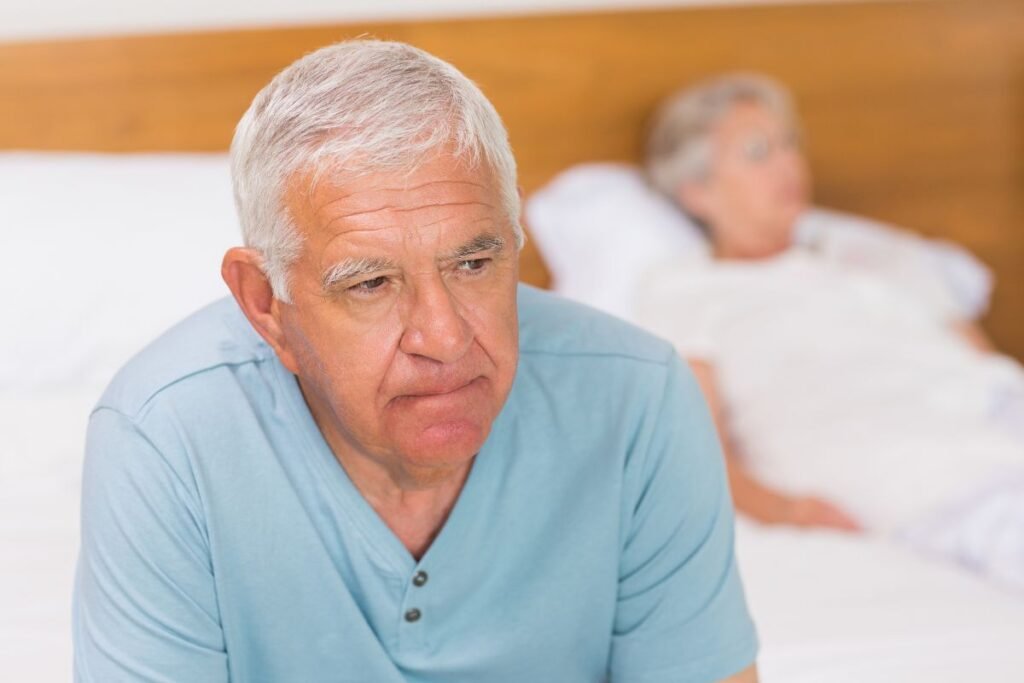 Homme retraité pensif assis sur le lit, exprimant la difficulté à trouver du sens et des repères après la retraite