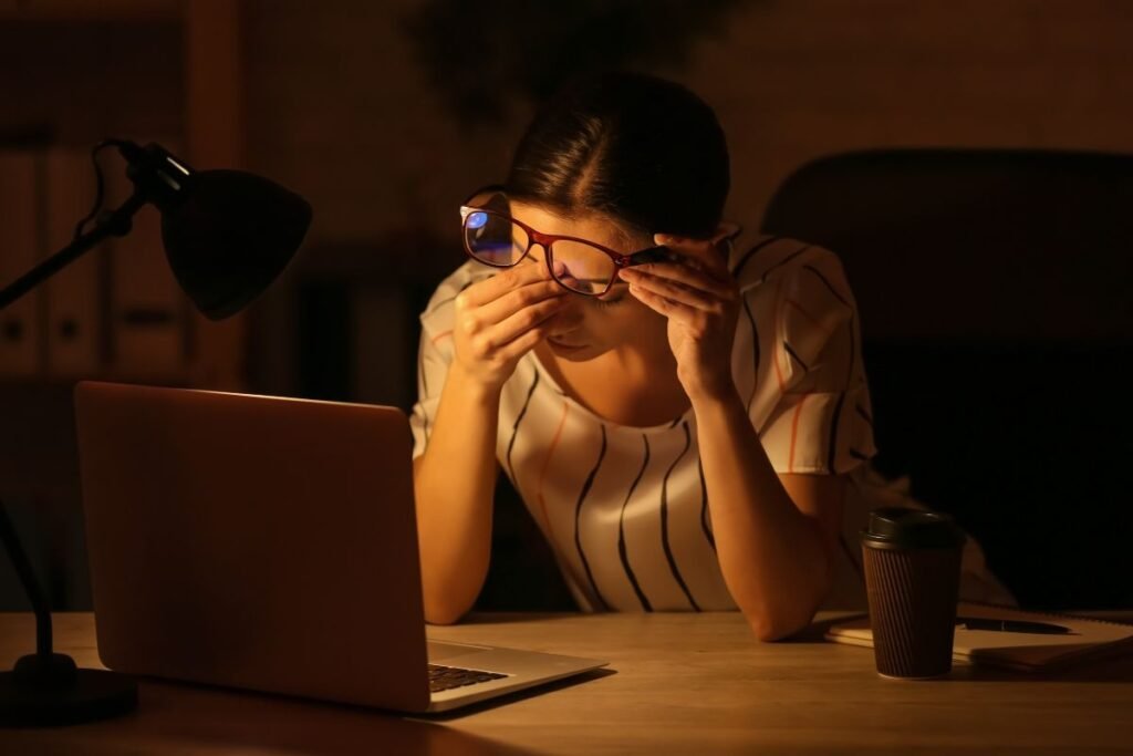 Dirigeante fatiguée devant son ordinateur la nuit, submergée par une surcharge décisionnelle.