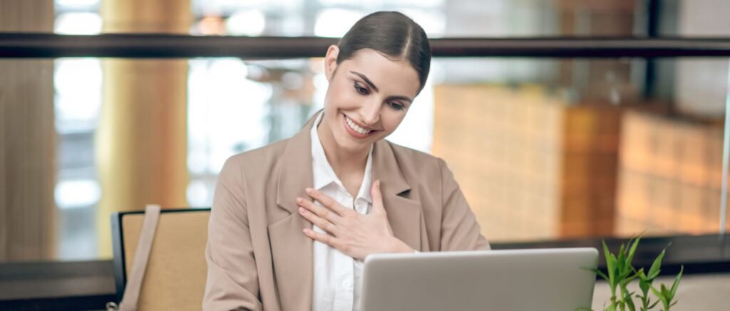 DRH souriante devant son ordinateur après un accompagnement en coaching, exprimant confiance et soulagement.