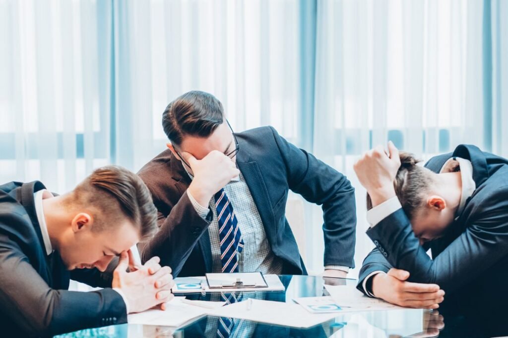 Managers en réunion submergés par la fatigue et le stress, illustrant les effets du manque de temps de réflexion.