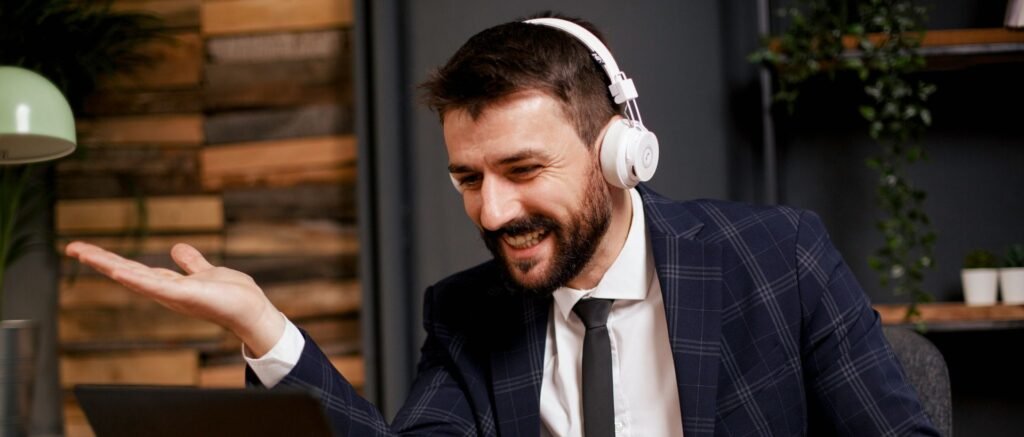 Cadre en visioconférence, souriant et confiant, illustrant la réussite d’un coaching pour rebondir après une rupture professionnelle.