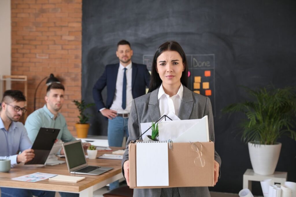 Collaboratrice quittant son poste après un licenciement lors d’une restructuration.