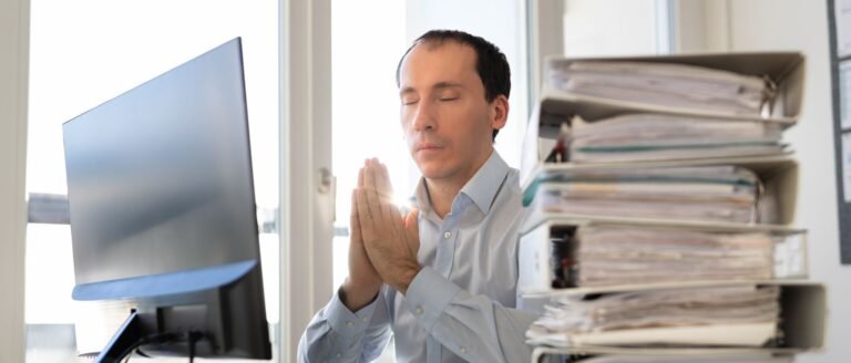 Cadre surchargé de dossiers prenant un moment de recul au travail.