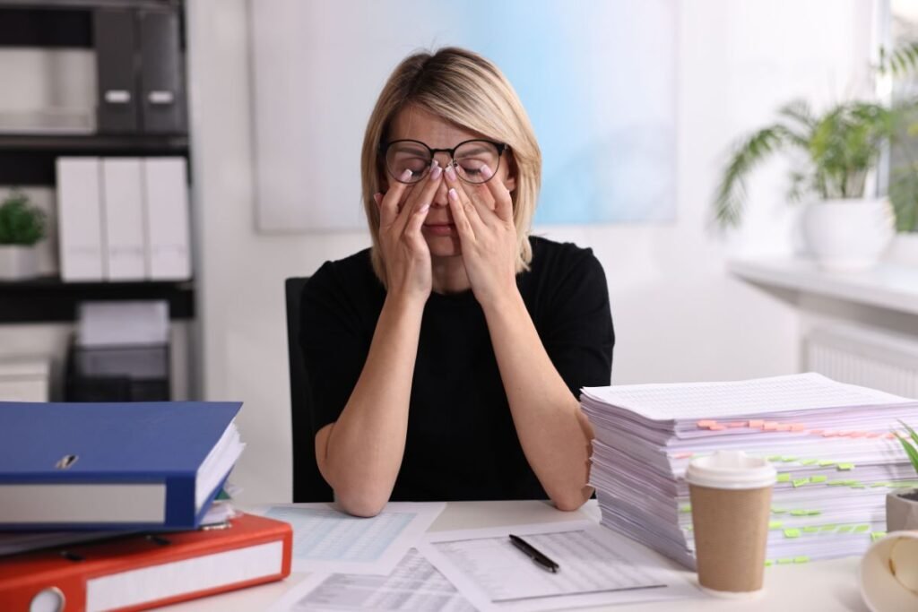 Manager épuisée face à une surcharge de travail et des dossiers accumulés.