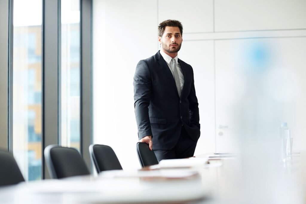 Responsable RH seul dans une salle de réunion après une décision de restructuration.