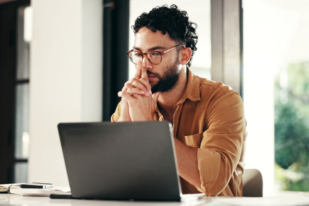 Cadre expatrié pensif devant son ordinateur, illustrant la perte de repères culturels et personnels.